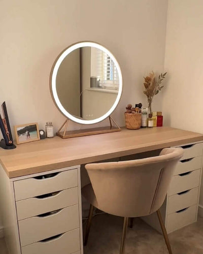 Anne Round Hollywood Mirror with Gold Frame on a stylish vanity table in a modern dressing room with customizable LED lighting.