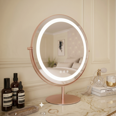 Round illuminated makeup mirror on a stand with skincare products on a marble surface.