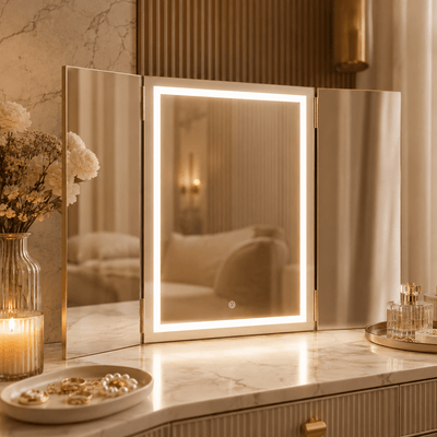 Gold trifold makeup mirror with LED lights on a marble dressing table