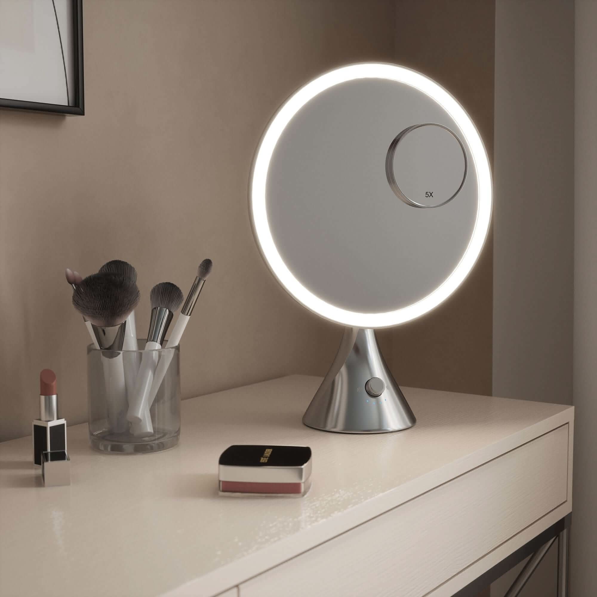 LumiGlam Pro Cosmetic Vanity Mirror in Chrome with illuminated design on table next to makeup tools.