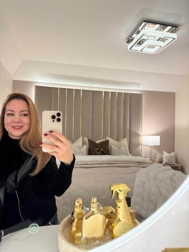 Ava Round Wall Mounted Mirror 80cm reflecting a modern bedroom with stylish decor and perfume bottles.