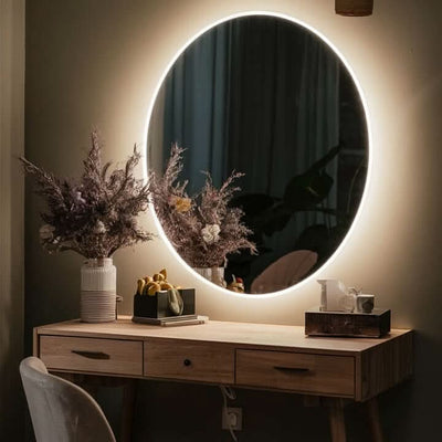 Luna 80cm round backlit mirror with ambient glow, enhancing a modern vanity setup with floral decor.