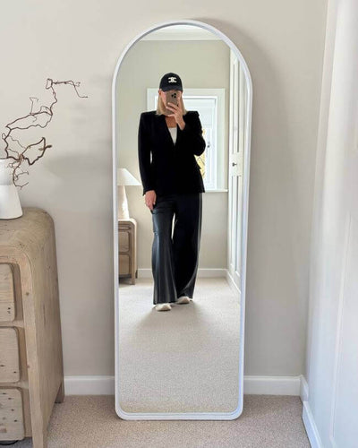 Sophia Full Length Arch Mirror White Frame with person reflection, featuring sleek design and LED lighting, in bedroom setting.