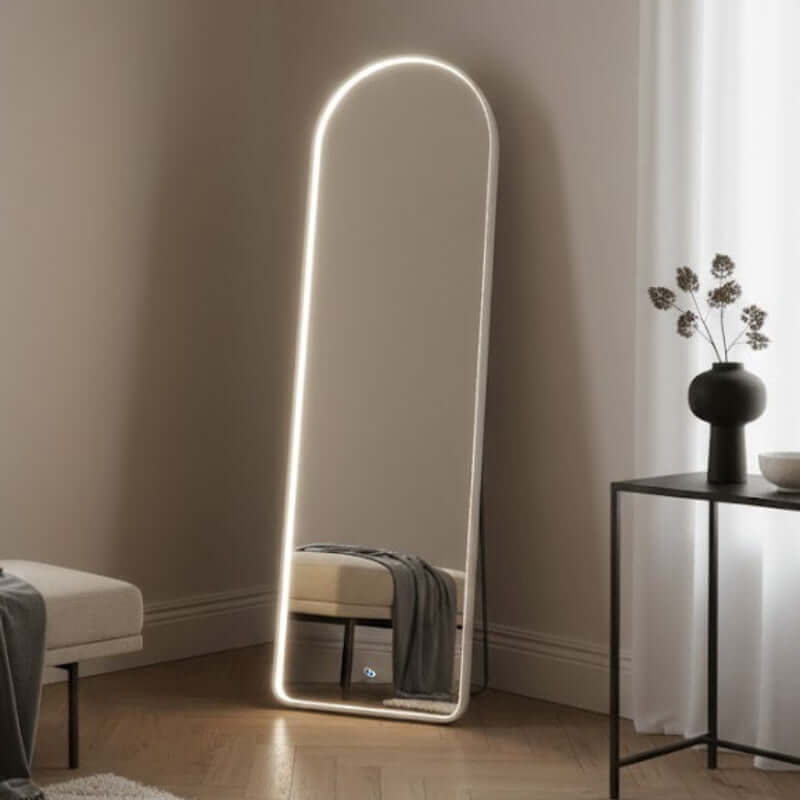 Modern floor mirror with LED lighting in a minimalistic room.