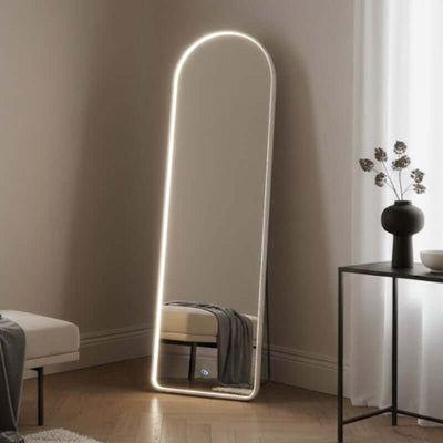 Modern floor mirror with LED lighting in a minimalistic room.