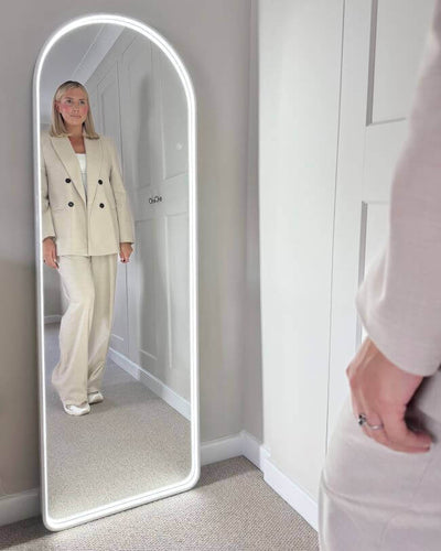 Sophia Full Length Arch Mirror White Frame with LED light, showing a woman standing reflected, perfect for stylish interiors.