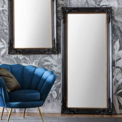 Antique Black Large Harrelson Mirror with baroque mouldings, positioned in a stylish room beside a blue chair and decorative wall.