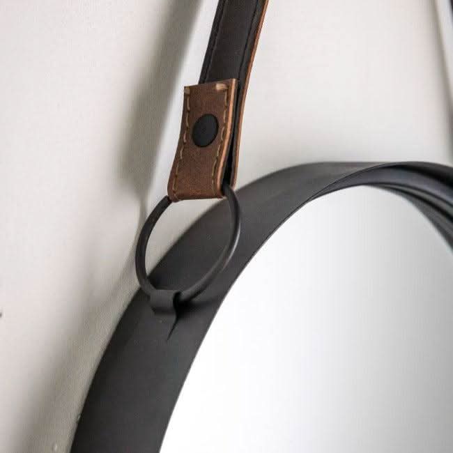 Close-up of metal framed Marston mirror with black faux leather hanging strap.