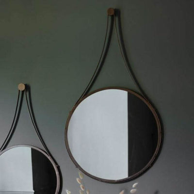 Large Broadway round mirror with metal frame and hanging strap, adding rustic flair to walls, sized 510mm x 915mm. Delivery in 7-10 days.