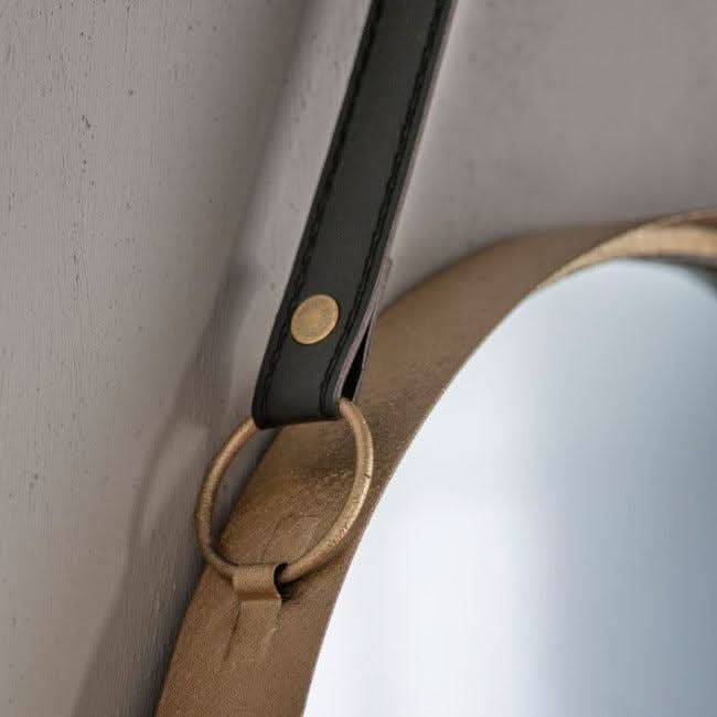 Close-up of a gold metal-framed mirror with black faux leather strap, highlighting elegant details of the set of two Marston Hanging Mirrors.