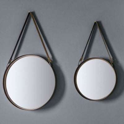 Set of two round bronze metal framed mirrors with black faux leather straps, ideal for living or home office decor.