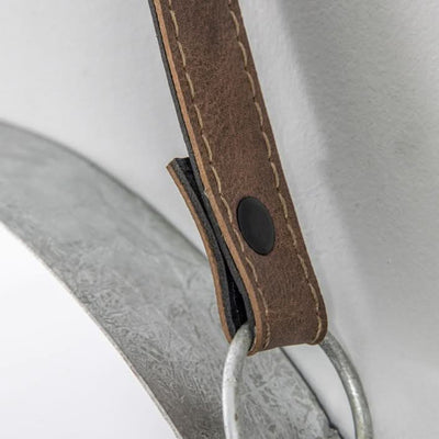 Close-up of black faux leather hanging strap on silver metal framed Marston mirror