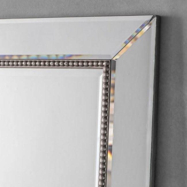 Close-up of Regent Rectangular Beaded Mirror with bevelled edges and elegant beading detail on a grey background.