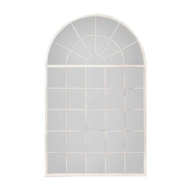 Silver Hemsworth leaner mirror with arched window pane style, elegantly leaning against a wall next to a modern plant stand.