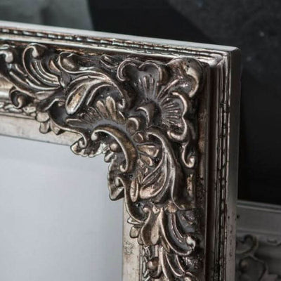 Close-up of intricate silvery design on small Fiennes mirror frame, exemplifying elegant home decor style.