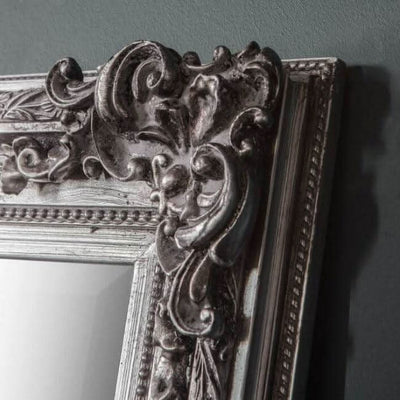 Close-up of stone gray small baroque-style mirror frame with intricate detailing, classic wall decor for a sophisticated look.
