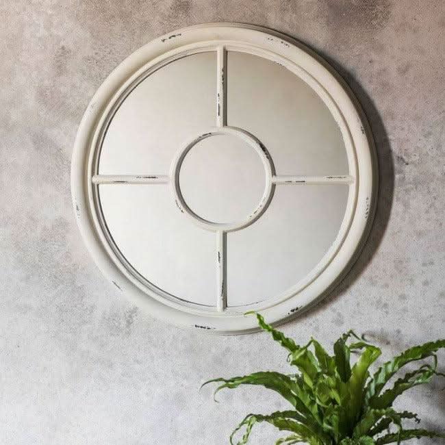 Vintage white round mirror with porthole design, light crackle texture, on rustic wooden wall. Ideal for nautical-themed decor.