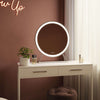 Luxurious Isla Round Hollywood Mirror with silver frame and LED lighting on a vanity table, 60x63cm.