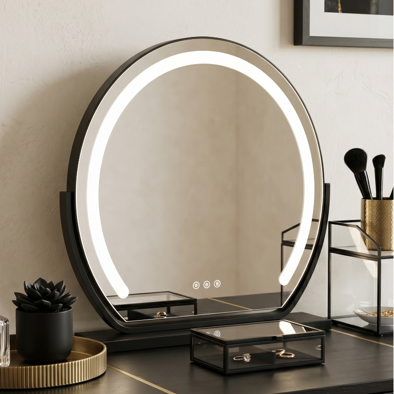 black Round illuminated vanity mirror on a marble countertop with skincare products.
