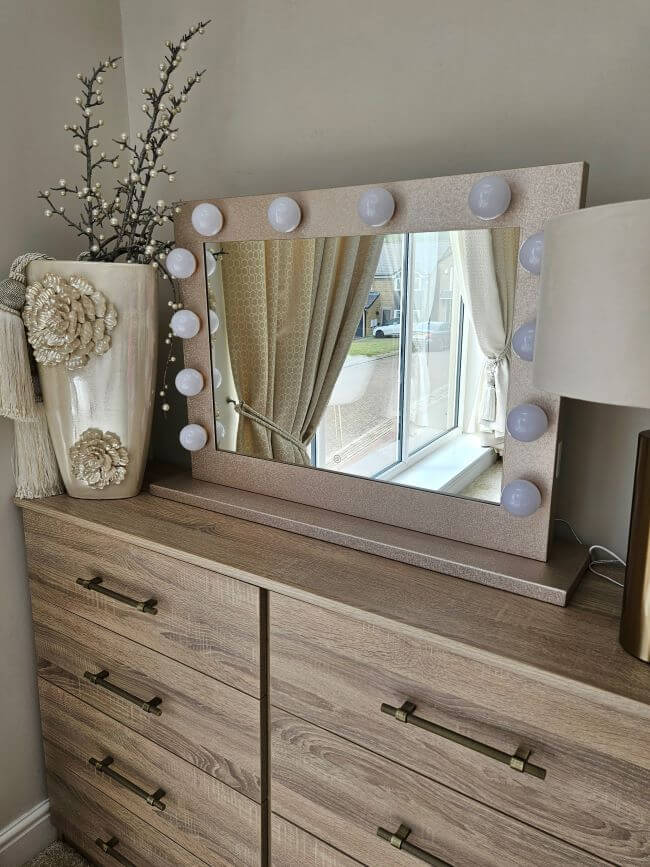 Jolie Gold Hollywood Mirror 80x60cm with lights reflecting a stylish bedroom, perfect for makeup and glamorous setups.