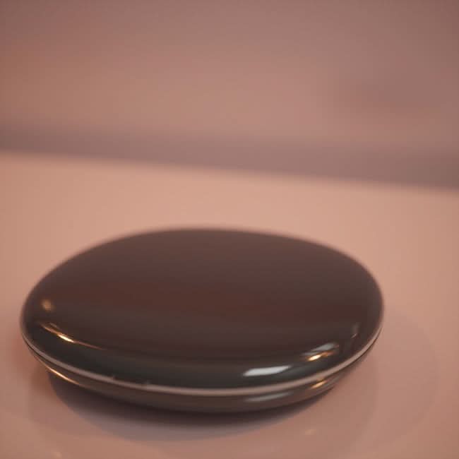 The Black Compact Mirror with Light, featuring a smooth oval shape and glossy dark finish, sits on a light-colored surface, showcasing its modern, minimalist design as both a handy gadget and decorative accessory.