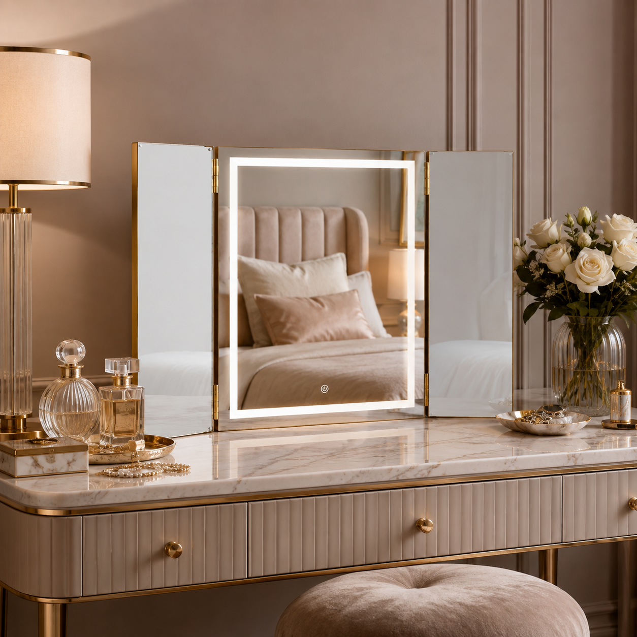 Gold LED trifold vanity mirror styled with perfume and beauty accessories