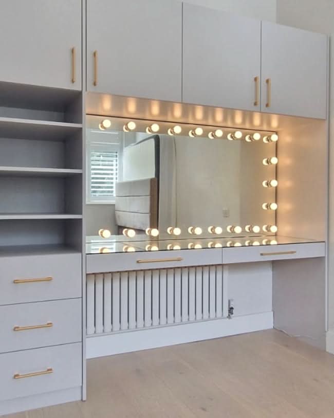 Full-length Hollywood mirror with lights integrated into a stylish dressing area, featuring bright white bulbs and storage cabinets.