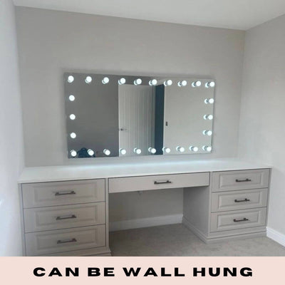 Hollywood mirror with LED bulbs, wall mounted above a white vanity table, provides perfect lighting for makeup, text: 'Can Be Wall Hung'