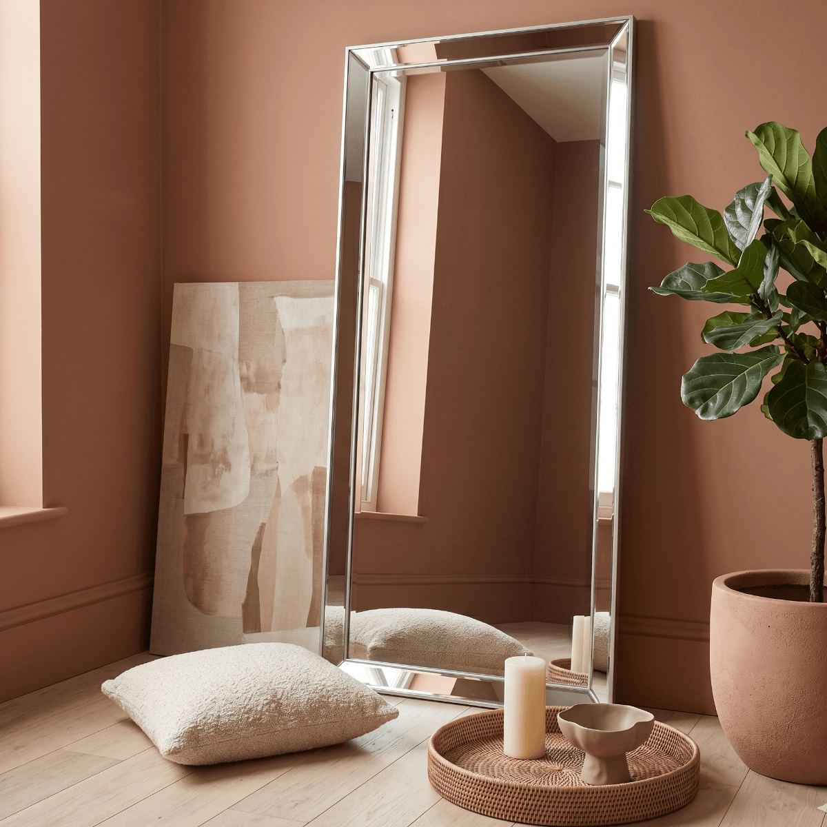 Silver full length floor leaner mirror styled in warm terracotta living room with fiddle leaf fig plant and rattan tray — Hollywood Mirrors