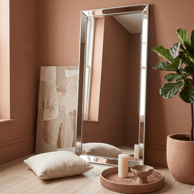 Silver full length floor leaner mirror styled in warm terracotta living room with fiddle leaf fig plant and rattan tray — Hollywood Mirrors