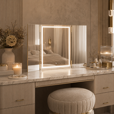 Lux Gold lighted trifold vanity mirror in an elegant neutral bedroom