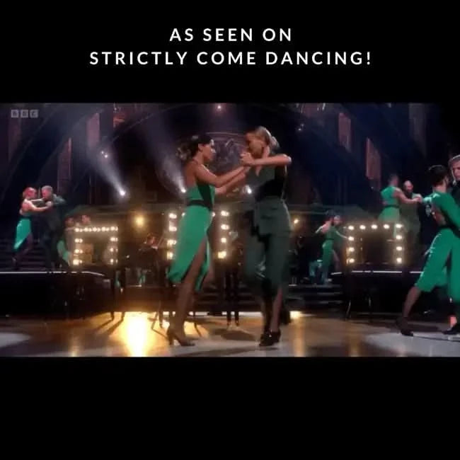 Dancers performing on stage in green outfits with bright lights, as seen on Strictly Come Dancing.