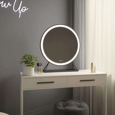 Luxurious black frame Hollywood mirror with LED lighting sits elegantly on a white vanity in a stylish room, adding sophistication.