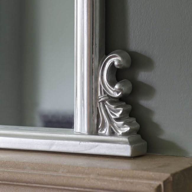 Close-up of ornate silver corner detail on dome overmantle mirror with bevelled glass and luxurious silver leaf finish.