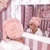 glamerous girl getting ready in mirror with lights pink bedroom