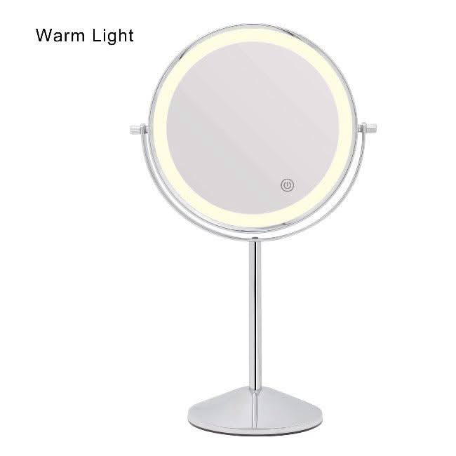 The Pre Order Mid June Illuminated Round Cosmetic Mirror has a 20cm diameter, a chrome adjustable stand, and features a circular warm LED light around the edge. Warm Light is displayed in the top left corner. Rechargeable design.