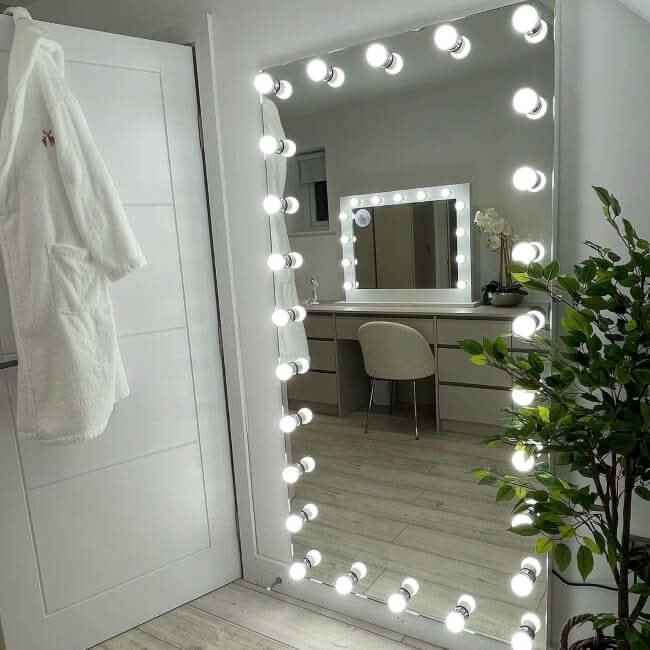 Keira XXL full-length Hollywood mirror with 28 bright bulbs, dimmer switch, white robe, and plant in stylish dressing room.