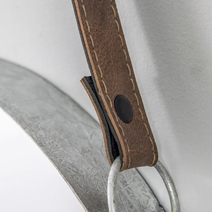 Close-up of black faux leather hanging strap on silver metal framed Marston mirror