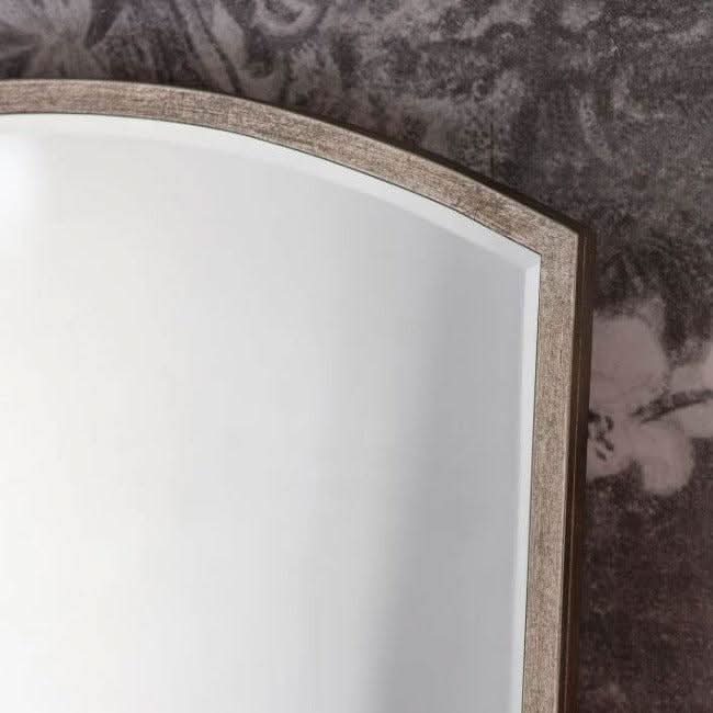 Moira Antique Silver Arch Mirror with minimalist design and thin metal frame, shown in close-up against floral background.