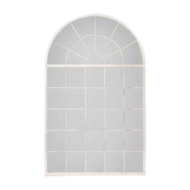 Silver Hemsworth leaner mirror with arched window pane style, elegantly leaning against a wall next to a modern plant stand.
