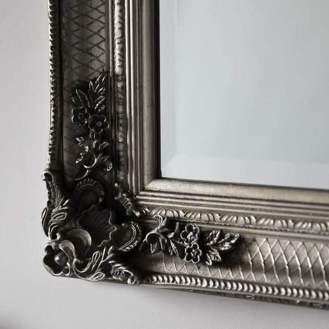Close-up of ornate silver frame on Victoria Baroque Leaner Mirror, showcasing intricate floral design and crafted wood details.
